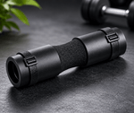 Black binoculars on a dark surface with a plant in the background