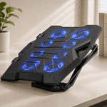 Black laptop cooling pad with blue LED lights on a desk