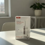 Box of a portable oral liquidizer on a table with a plant in the background At Aezoon