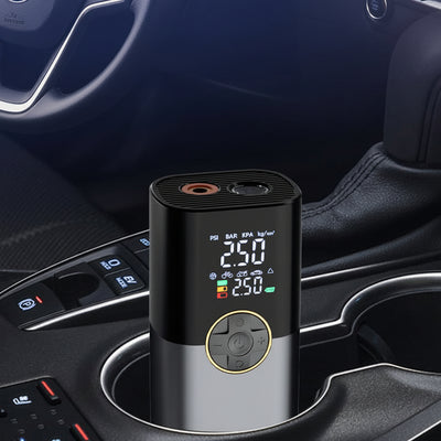 Car air compressor in a car cup holder with digital display and Chinese text on a dark background. At Aezoon