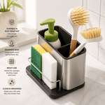 Free-standing stainless steel sink storage rack organizer holding a sponge, brush, and soap beside a kitchen sink