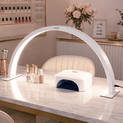 Gel nail lamp on a marble counter with decorative items in a salon setting