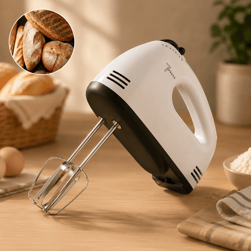 Hand mixer on a wooden table with bread and ingredients in the background