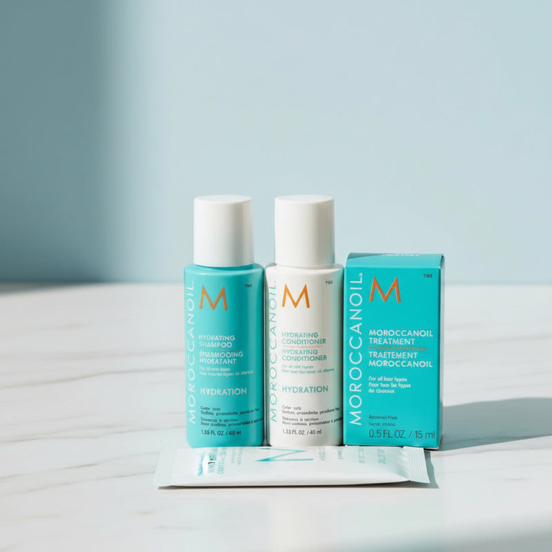 Moroccanoil hair care products including shampoo, conditioner, and treatment on a light surface with a light blue background. At Aeoon