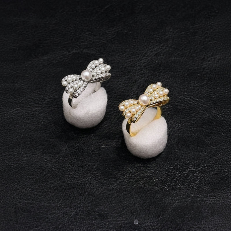 Pair of earrings with bow designs on a dark background At Aezoon